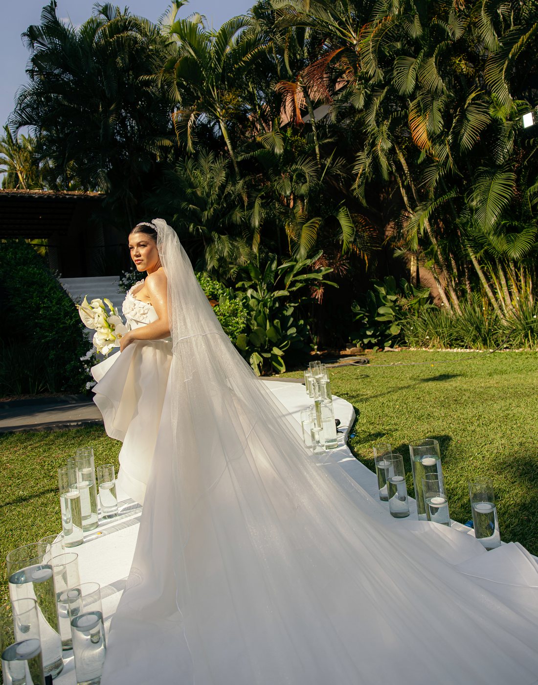 Noiva no jardim do Kauai Eventos, com a cauda do vestido sobre a passarela